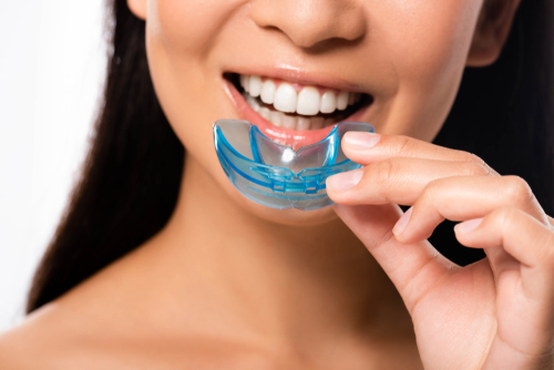 woman putting in a mouth guard 